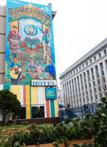 A 3-story mural depicting the Tenderloin Peoples' Garden.