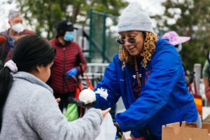 Volunteer Kiani puts an onion in a bag for a neighbor