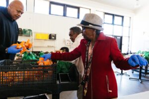 woman grabbing oranges to pack into plastic bags