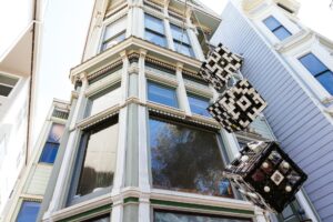 Miguel's artwork hangs in front of his window: 3 black and white cubes made from Venetian blinds. 