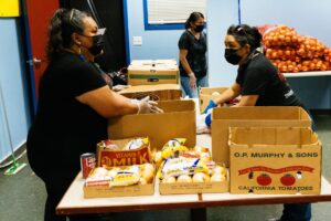 two women having a conversation while setting up a food pantry